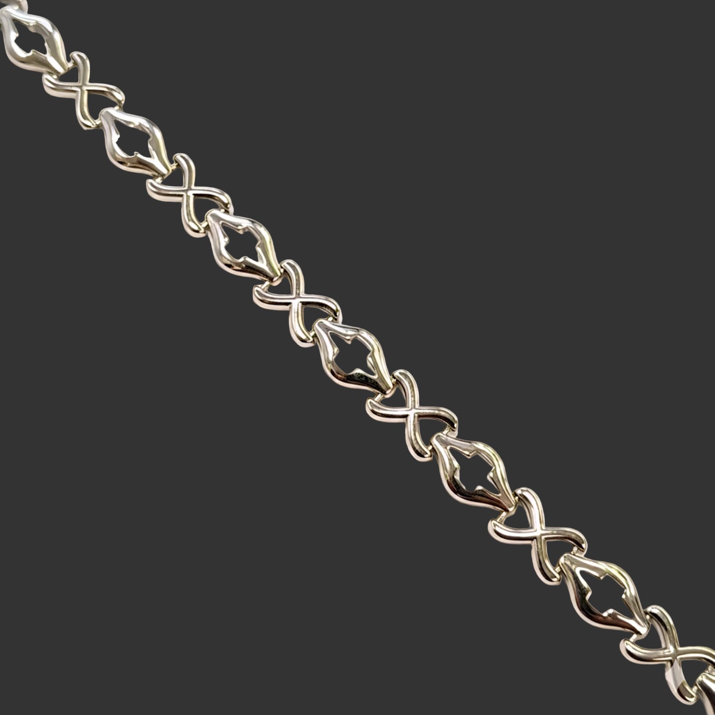 Silver bracelet with intricate links on a white background