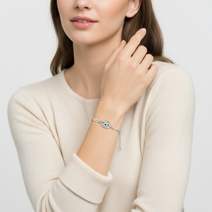 Woman wearing a silver bracelet with an eye design on a plain background