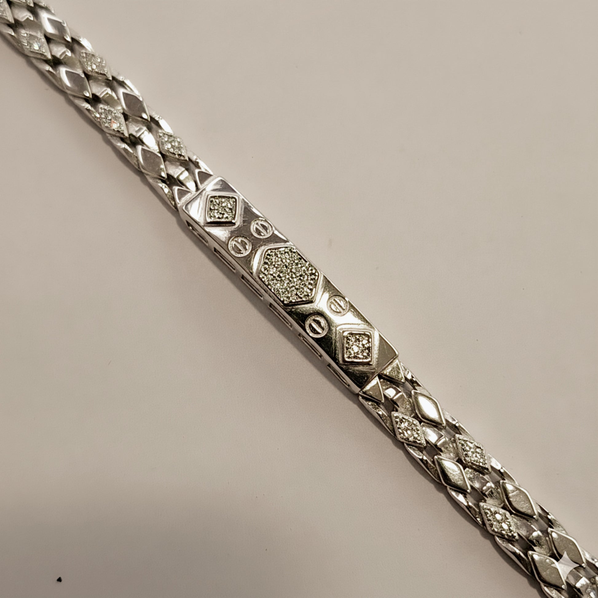 Silver bracelet with diamond-like stones on a beige background