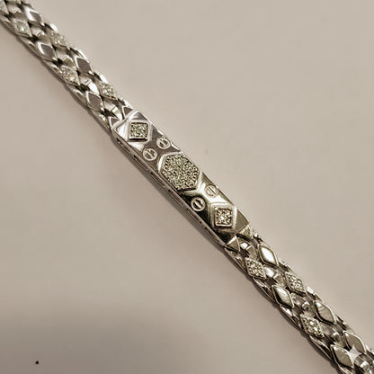Silver bracelet with diamond-like stones on a beige background