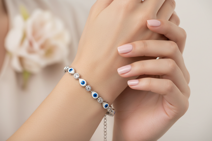 Close-up of a hand wearing a silver bracelet with blue and green beads.