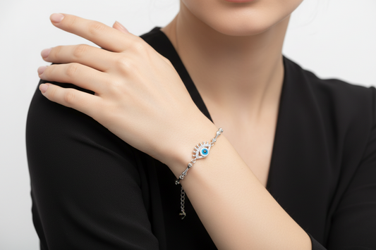 Silver bracelet with a blue eye charm on a white background
