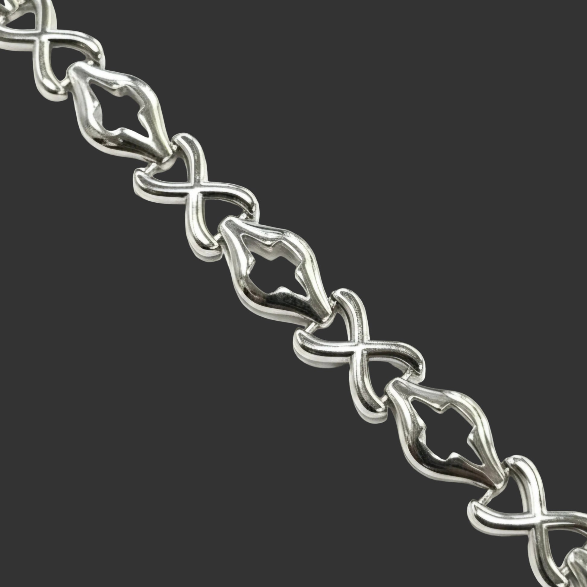 Close-up of a silver bracelet with intricate design on a white background