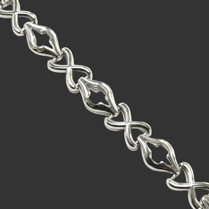 Close-up of a silver bracelet with intricate design on a white background
