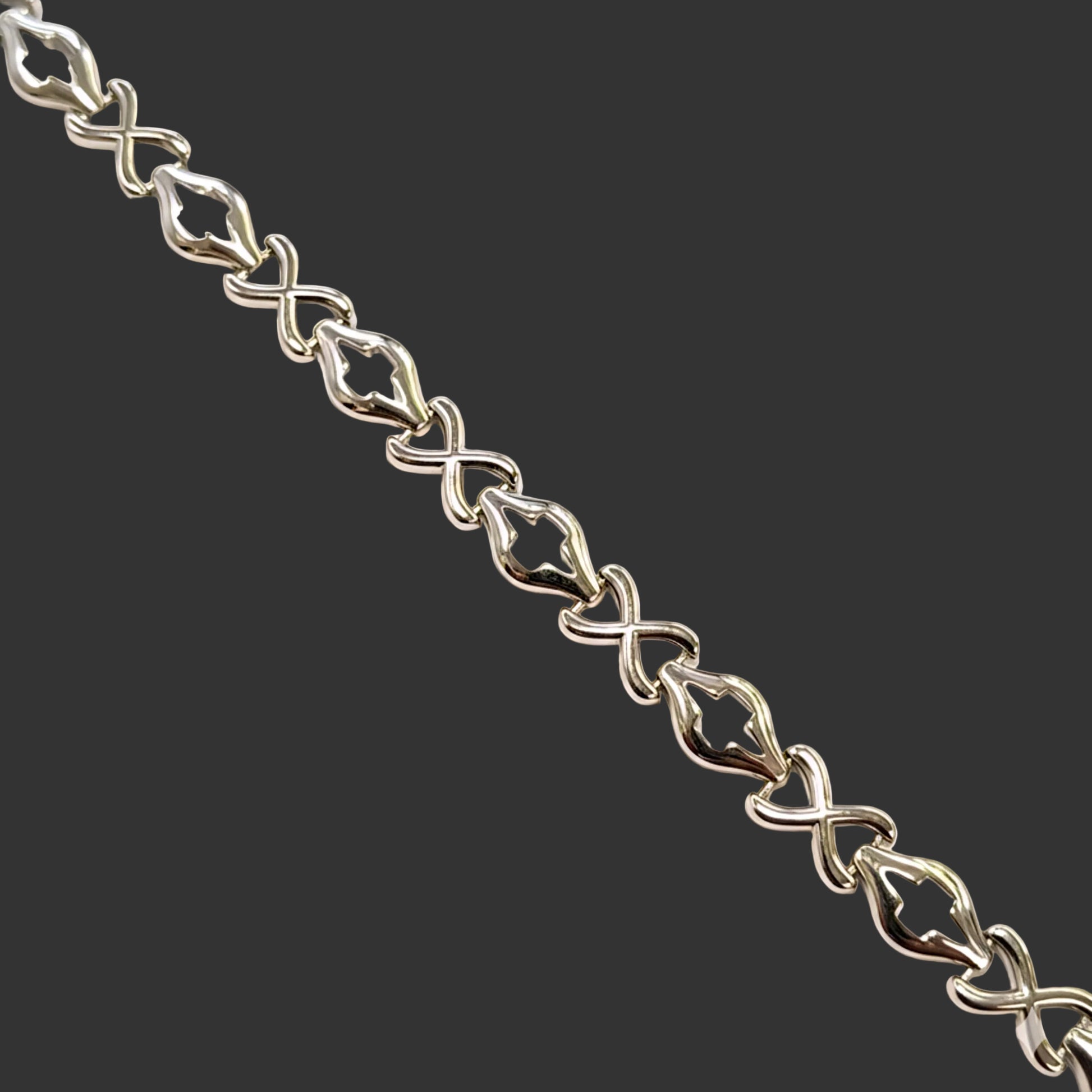 Silver bracelet with intricate links on a white background