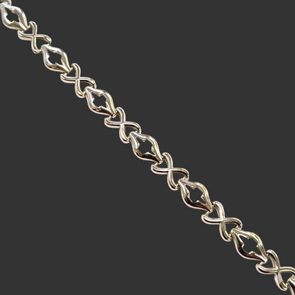 Silver bracelet with intricate links on a white background